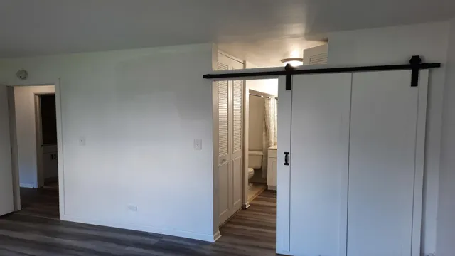 a view of a hallway with wooden floor and staircase