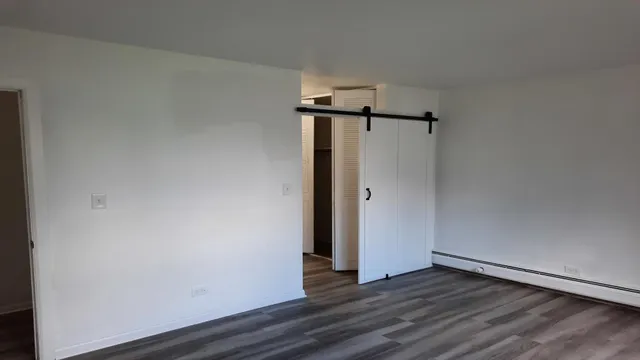 a view of an empty room with wooden floor