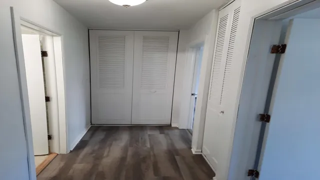 a view of a room with wooden floor and a small space