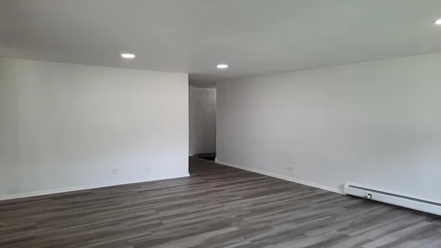a view of an empty room with wooden floor