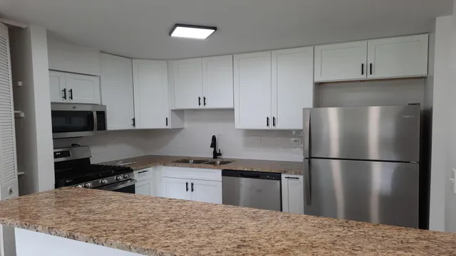 a kitchen with a refrigerator sink and cabinets