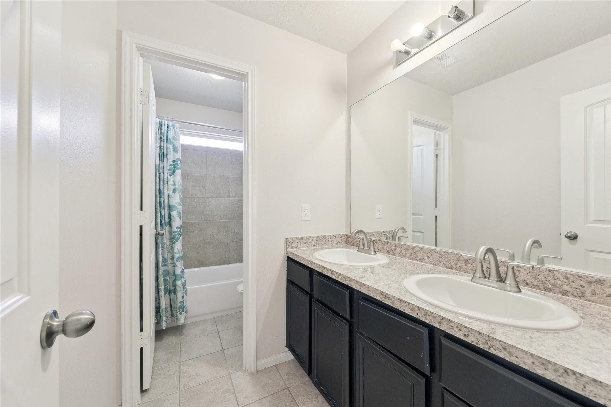 11718 Red Hummingbird Drive Houston, TX 77047 - Photo 12 of 13 a bathroom with a granite countertop sink and a mirror