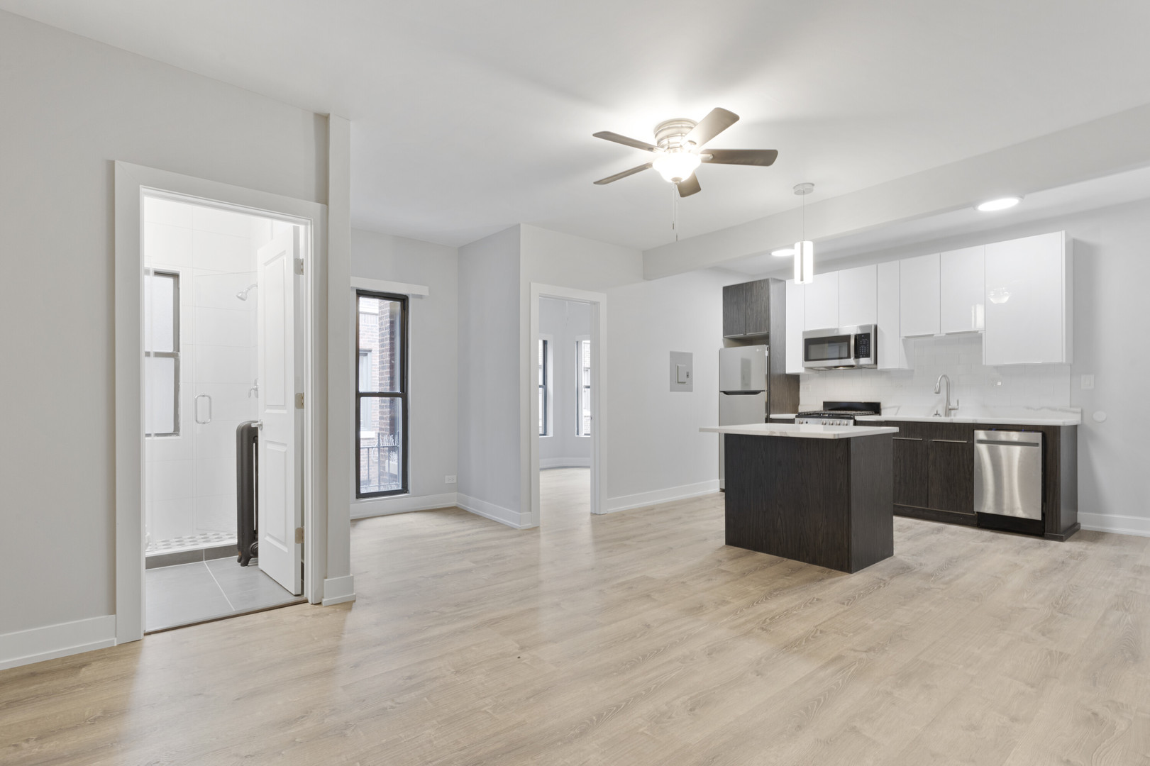 1651 West Jonquil Terrace, Unit 8 Chicago, IL 60626 - Photo 2 of 17 a large kitchen with stainless steel appliances kitchen island granite countertop a refrigerator and a sink
