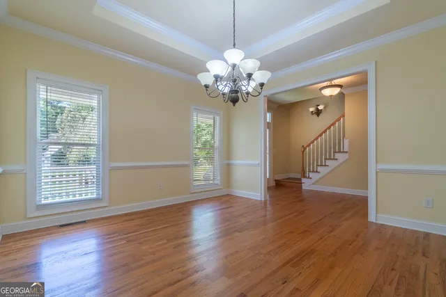 a view of an empty room with glass door and wooden floor