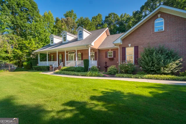 an aerial view of residential house with outdoor space and trees all around