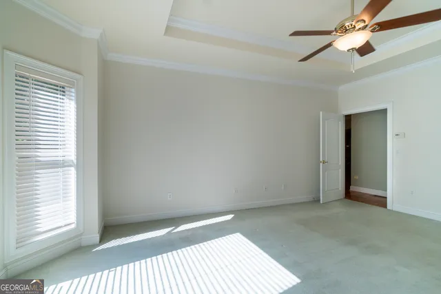 a view of an empty room with wooden floor and windows