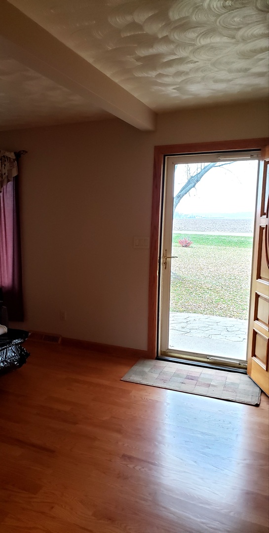 8776 Wolf Road Kingston, IL 60145 - Photo 7 of 35 a view of an empty room with wooden floor and a window