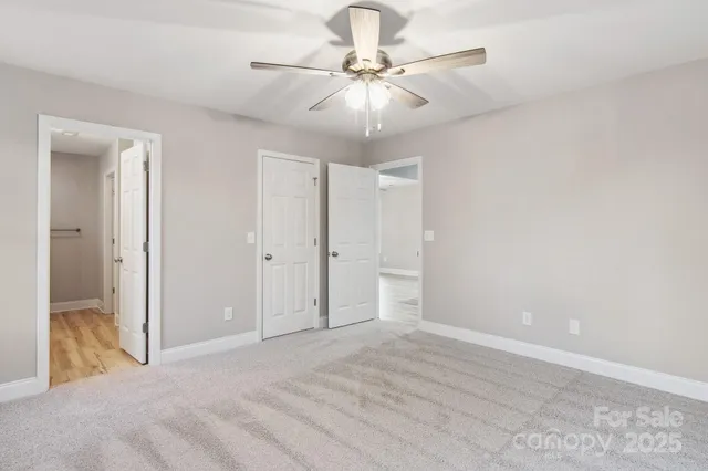 a view of a room with a ceiling fan and a window