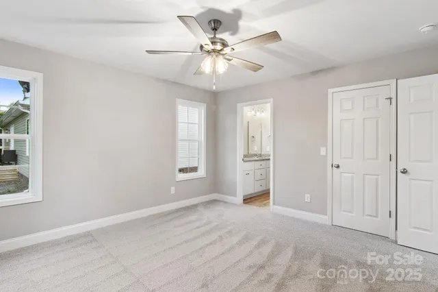 an empty room with fan and windows