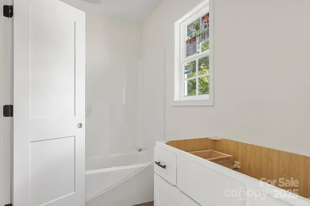 a bathroom with a tub sink and window