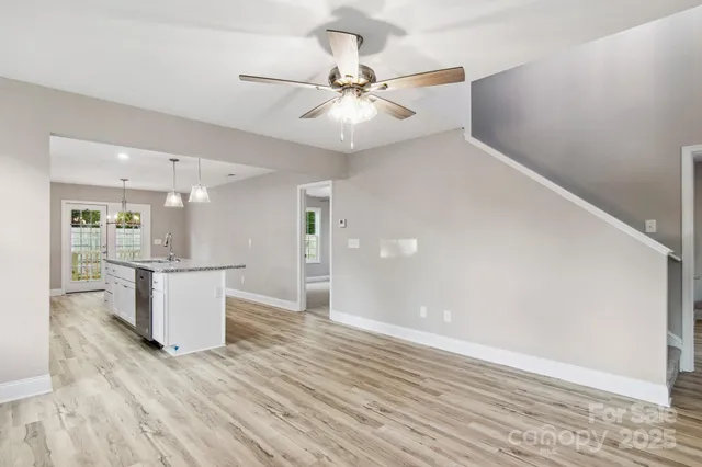 an empty room with wooden floor and ceiling fan