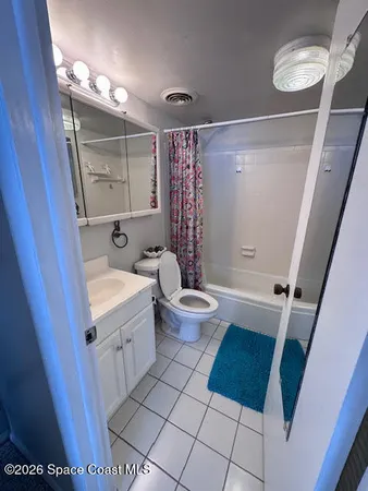 a bathroom with a sink a toilet a mirror and shower