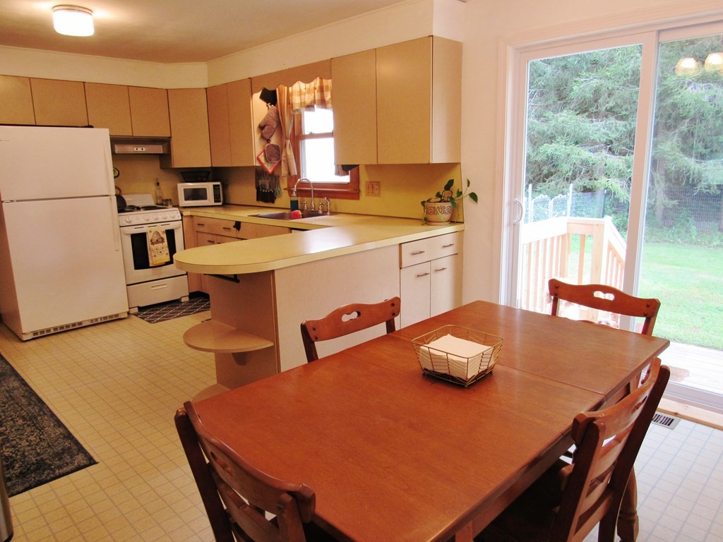 127 Springfield Street Three Rivers, MA 01080 - Photo 9 of 27 a kitchen with a table chairs and a refrigerator