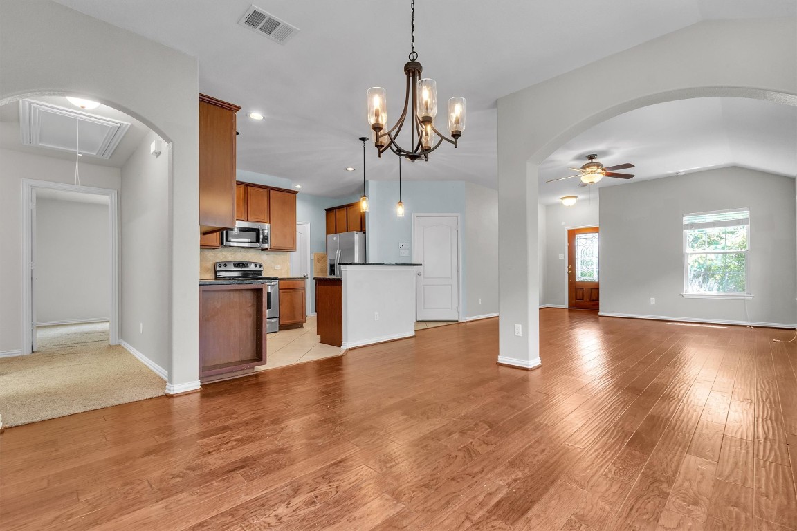 a view of a kitchen with a refrigerator wooden floor and a kitchen view