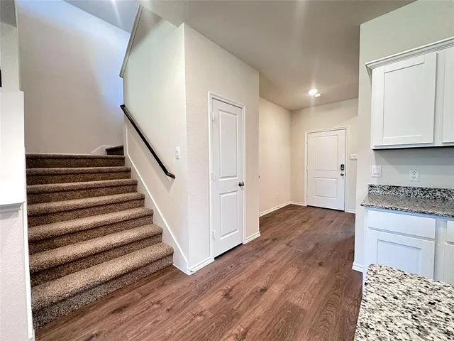 a view of a kitchen with wooden floor and stairs