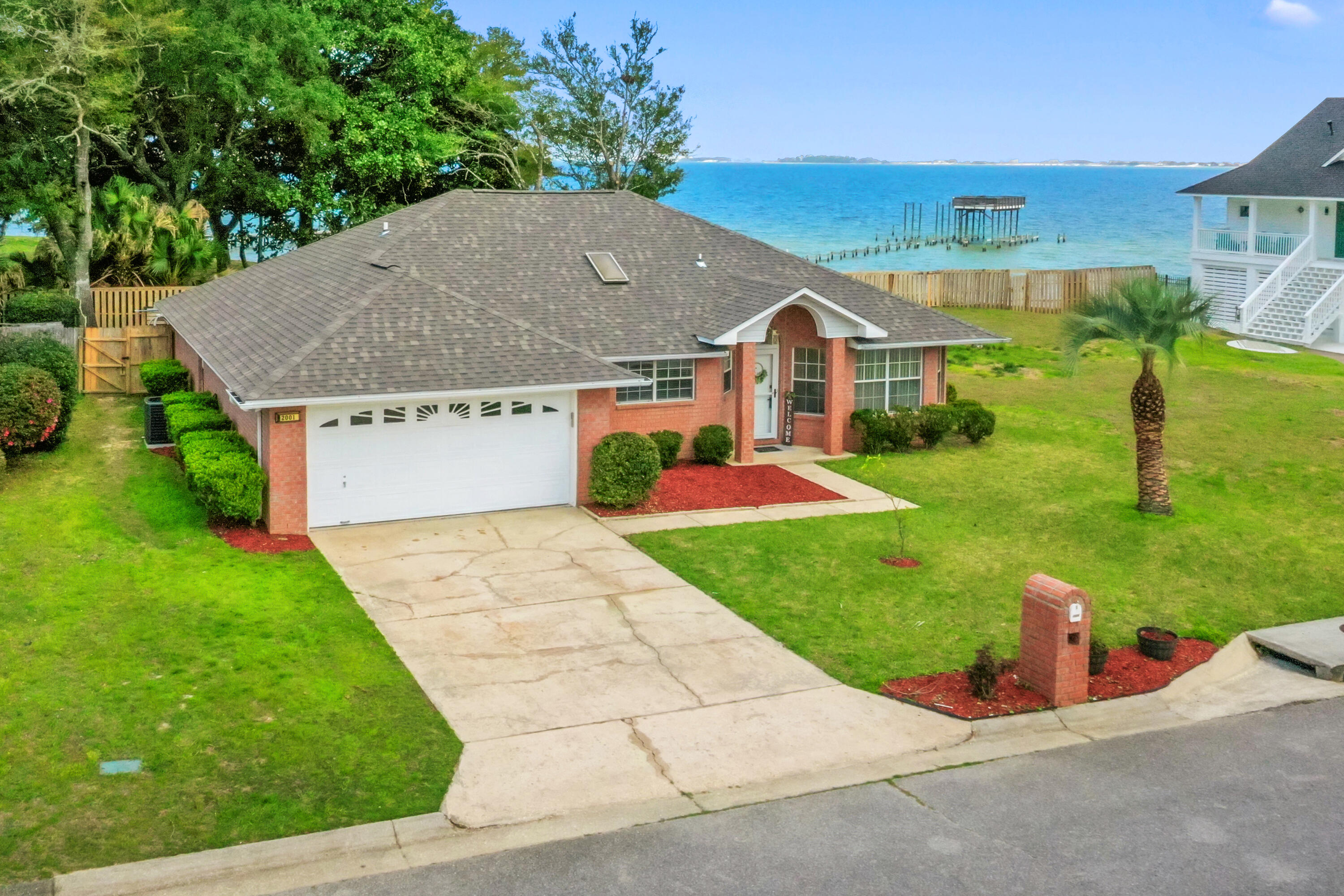 a aerial view of a house next to a big yard and large trees