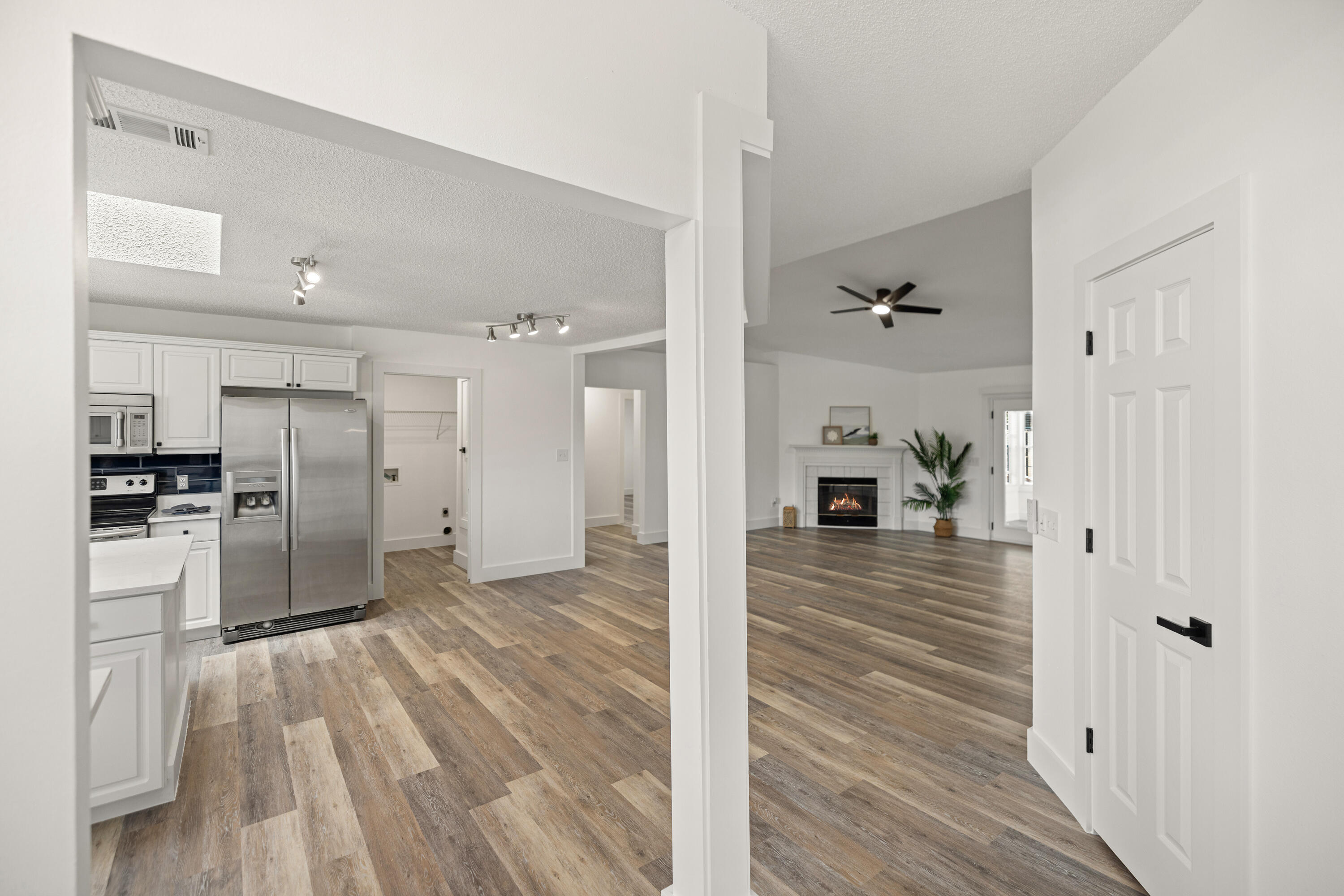 2001 Jessica Way Navarre, FL 32566 - Photo 11 of 73 a view of a hallway with wooden floor and a kitchen view