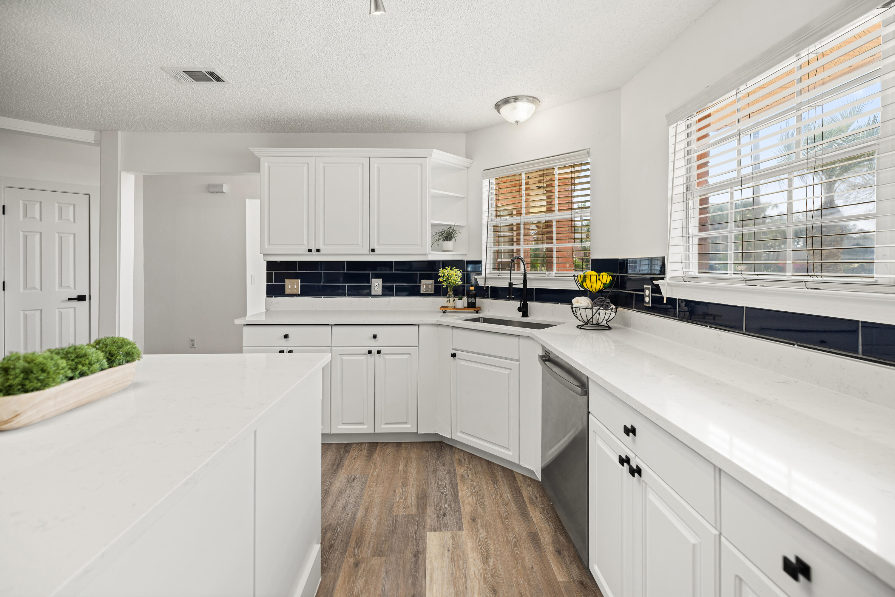 2001 Jessica Way Navarre, FL 32566 - Photo 20 of 73 a kitchen with stainless steel appliances sink a stove and white cabinets with wooden floor