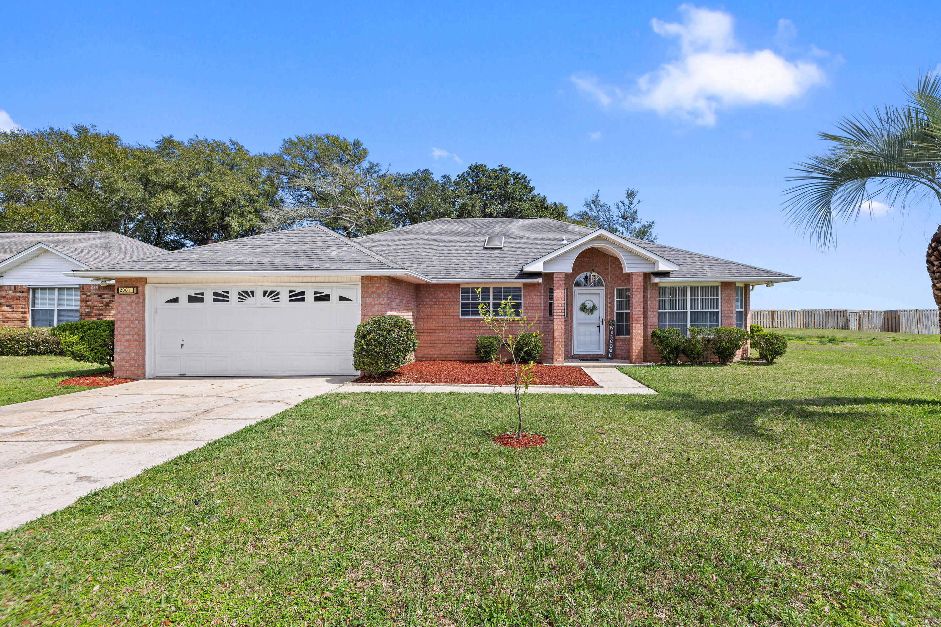 2001 Jessica Way Navarre, FL 32566 - Photo 3 of 73 a front view of a house with a yard and garage