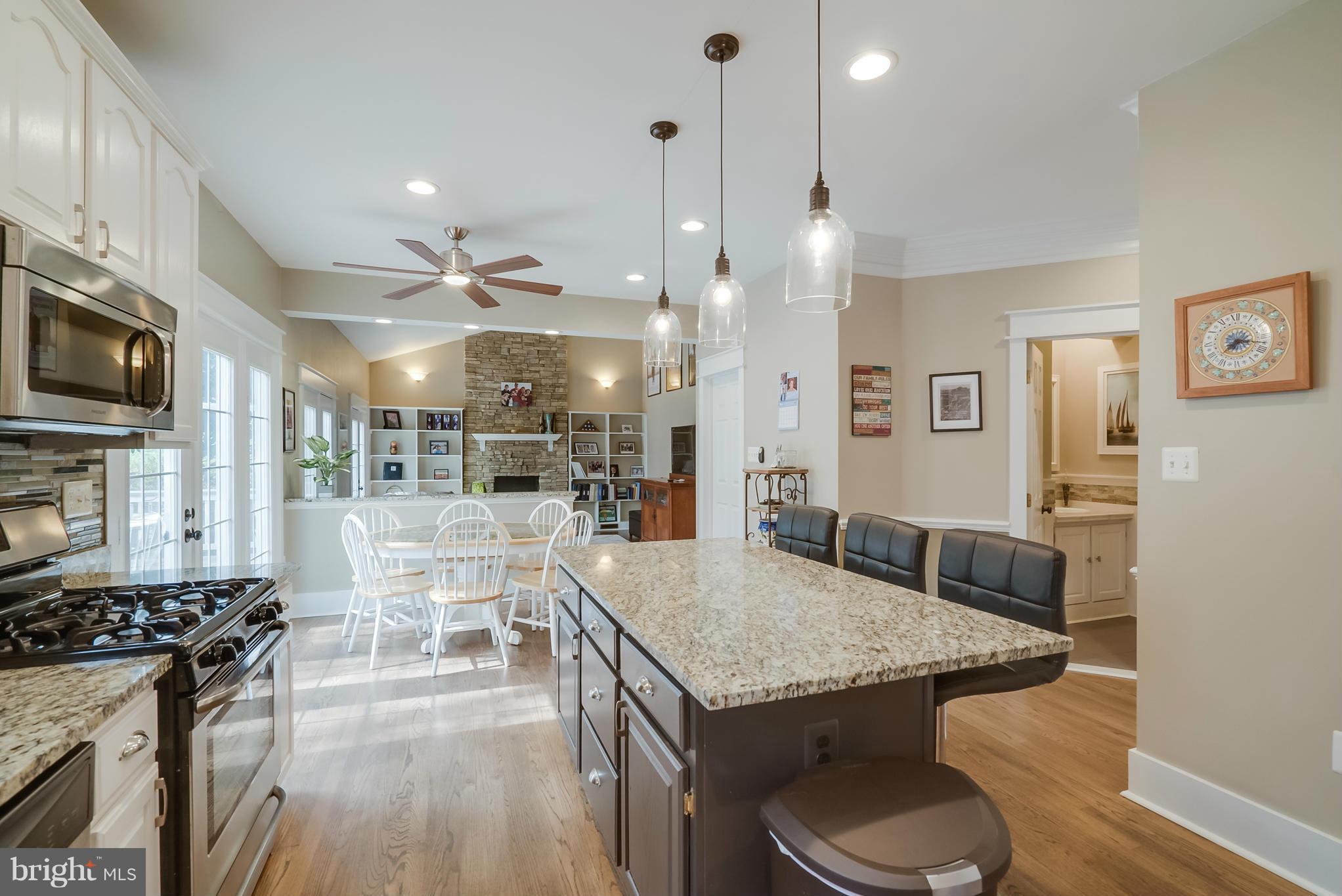 8759 Center Road Springfield, VA 22152 - Photo 5 of 30 a kitchen with stainless steel appliances granite countertop a stove top oven a sink dishwasher a dining table and chairs with wooden floor