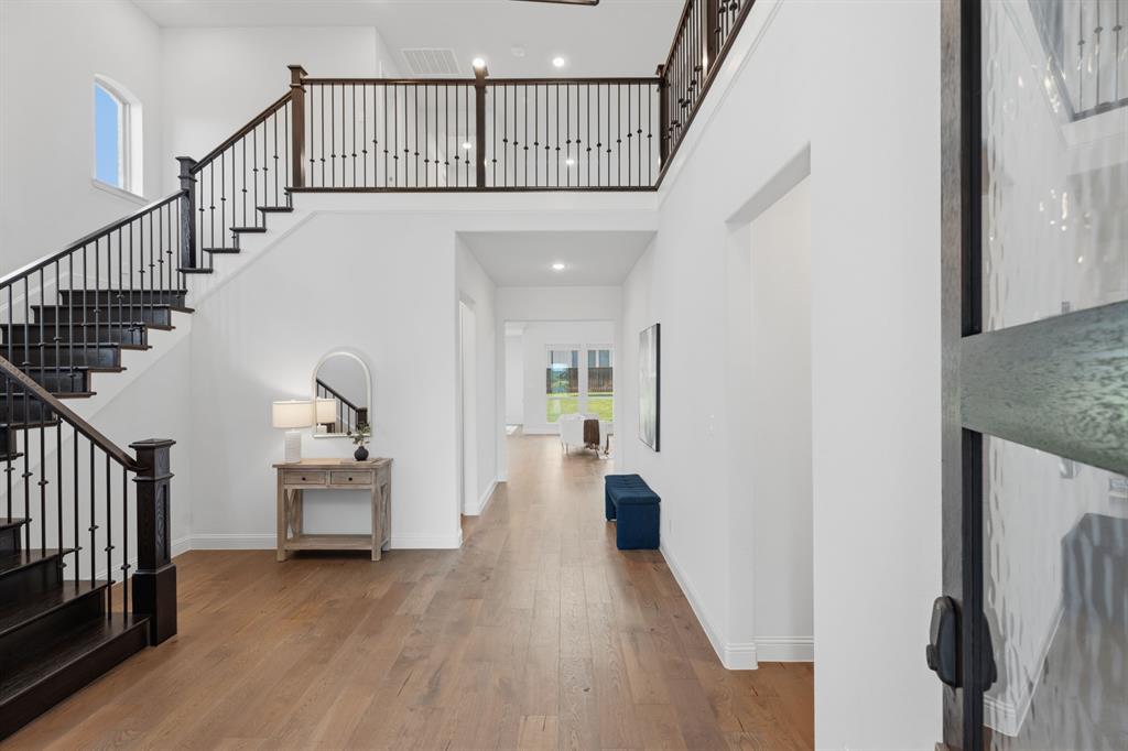 1316 Limestone Ridge Road Mansfield, TX 76063 - Photo 27 of 40 Grand staircase featuring dark wood-finish treads and risers with a black wrought iron baluster system
