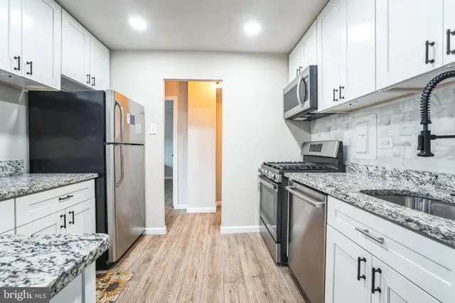 a kitchen with stainless steel appliances granite countertop a refrigerator and a stove top oven