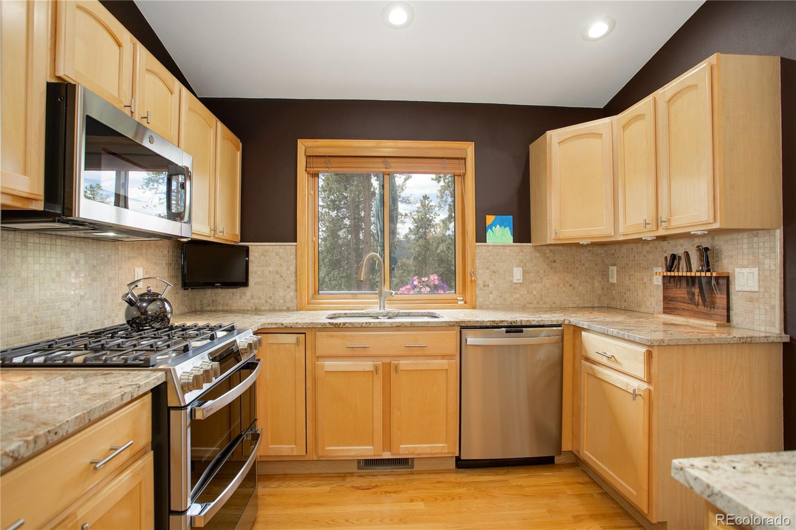 8360 South Warhawk Road Conifer, CO 80433 - Photo 13 of 40 a kitchen with stainless steel appliances granite countertop a stove a sink and a microwave