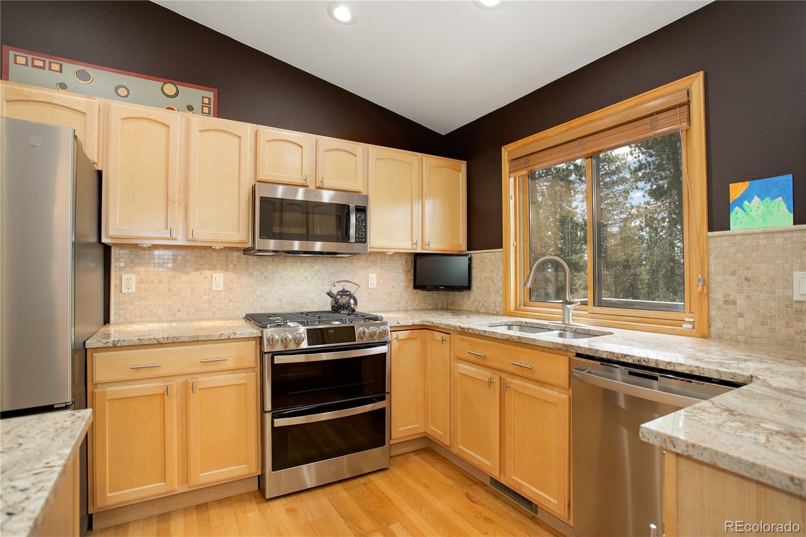 8360 South Warhawk Road Conifer, CO 80433 - Photo 14 of 40 a kitchen with stainless steel appliances a stove sink and microwave
