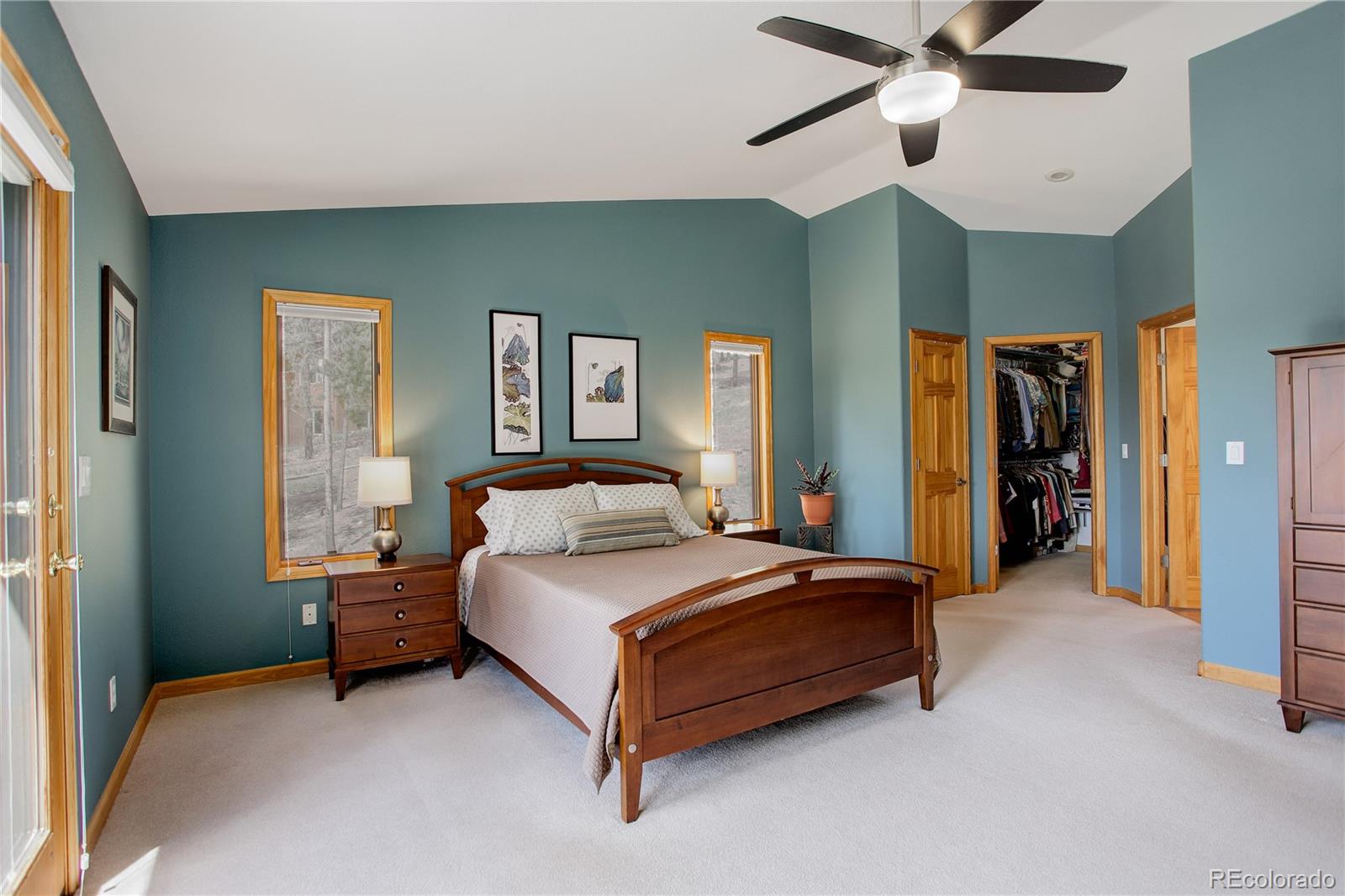 8360 South Warhawk Road Conifer, CO 80433 - Photo 17 of 40 a bedroom with a bed and a chandelier