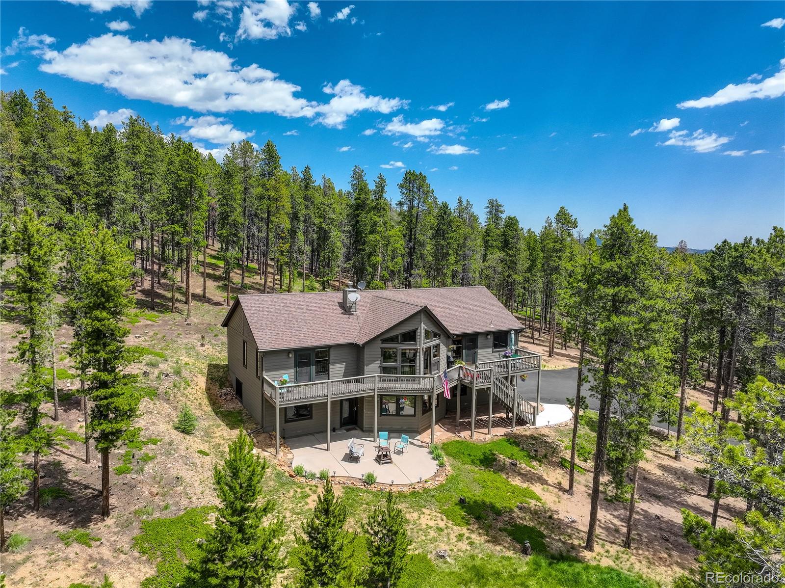 8360 South Warhawk Road Conifer, CO 80433 - Photo 2 of 40 a view of a house with yard and lake view