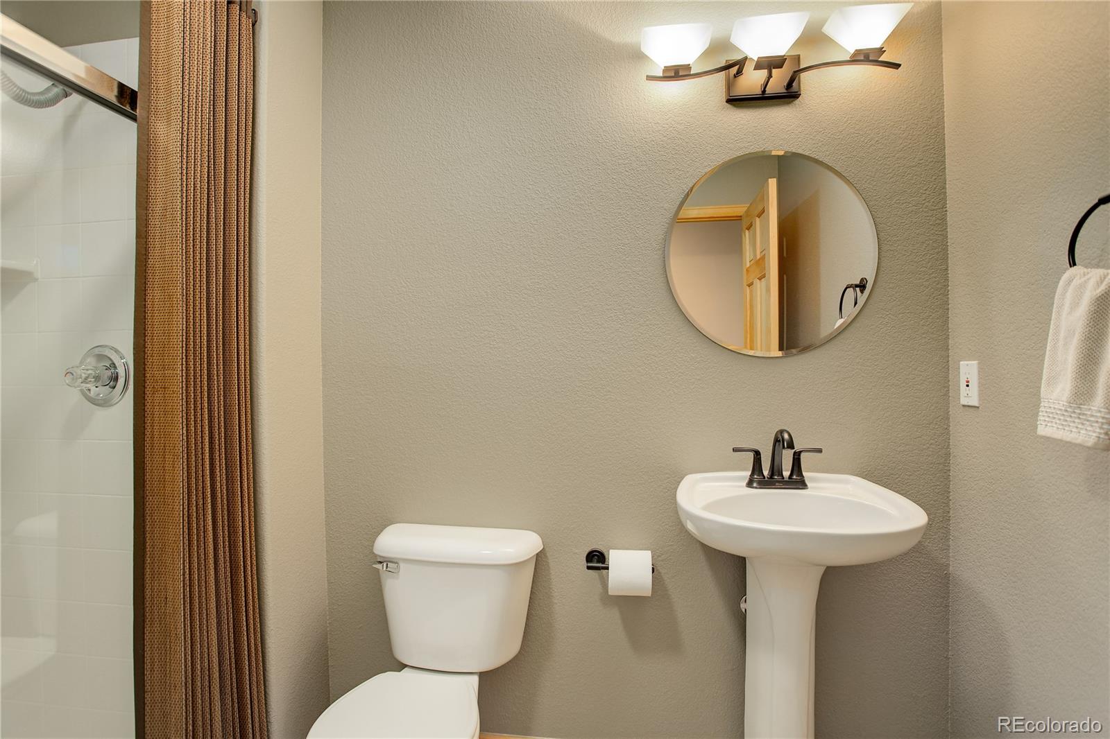 8360 South Warhawk Road Conifer, CO 80433 - Photo 24 of 40 a bathroom with a toilet sink and mirror