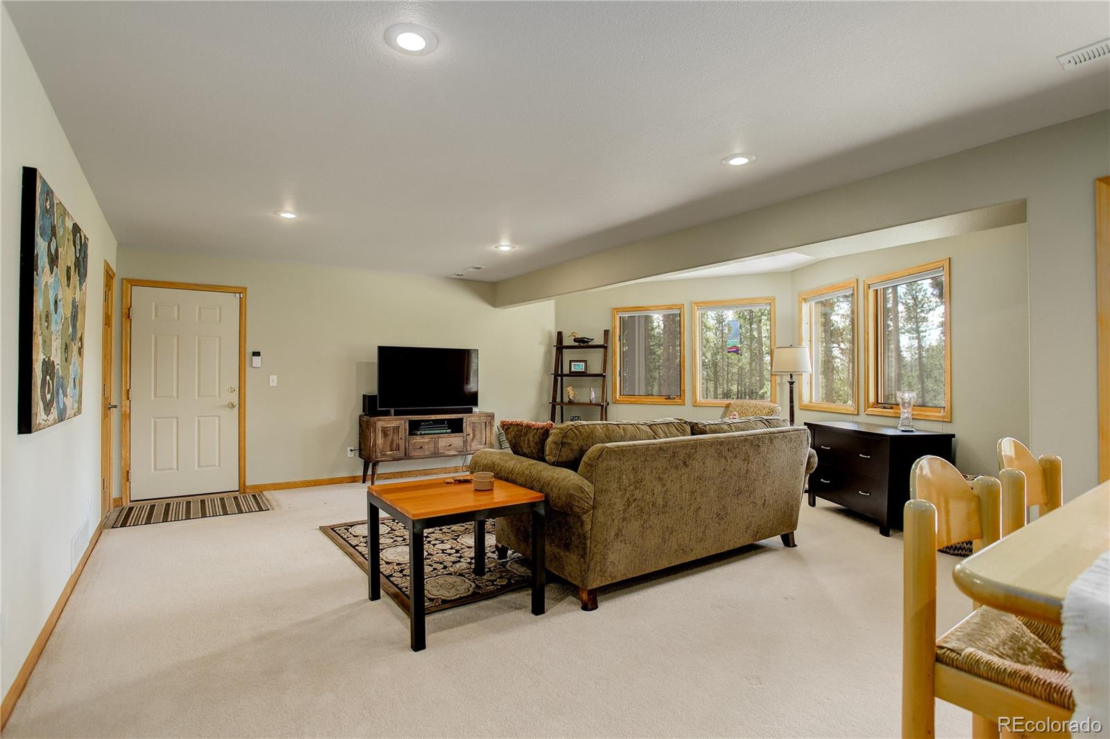 8360 South Warhawk Road Conifer, CO 80433 - Photo 26 of 40 a living room with furniture and a flat screen tv