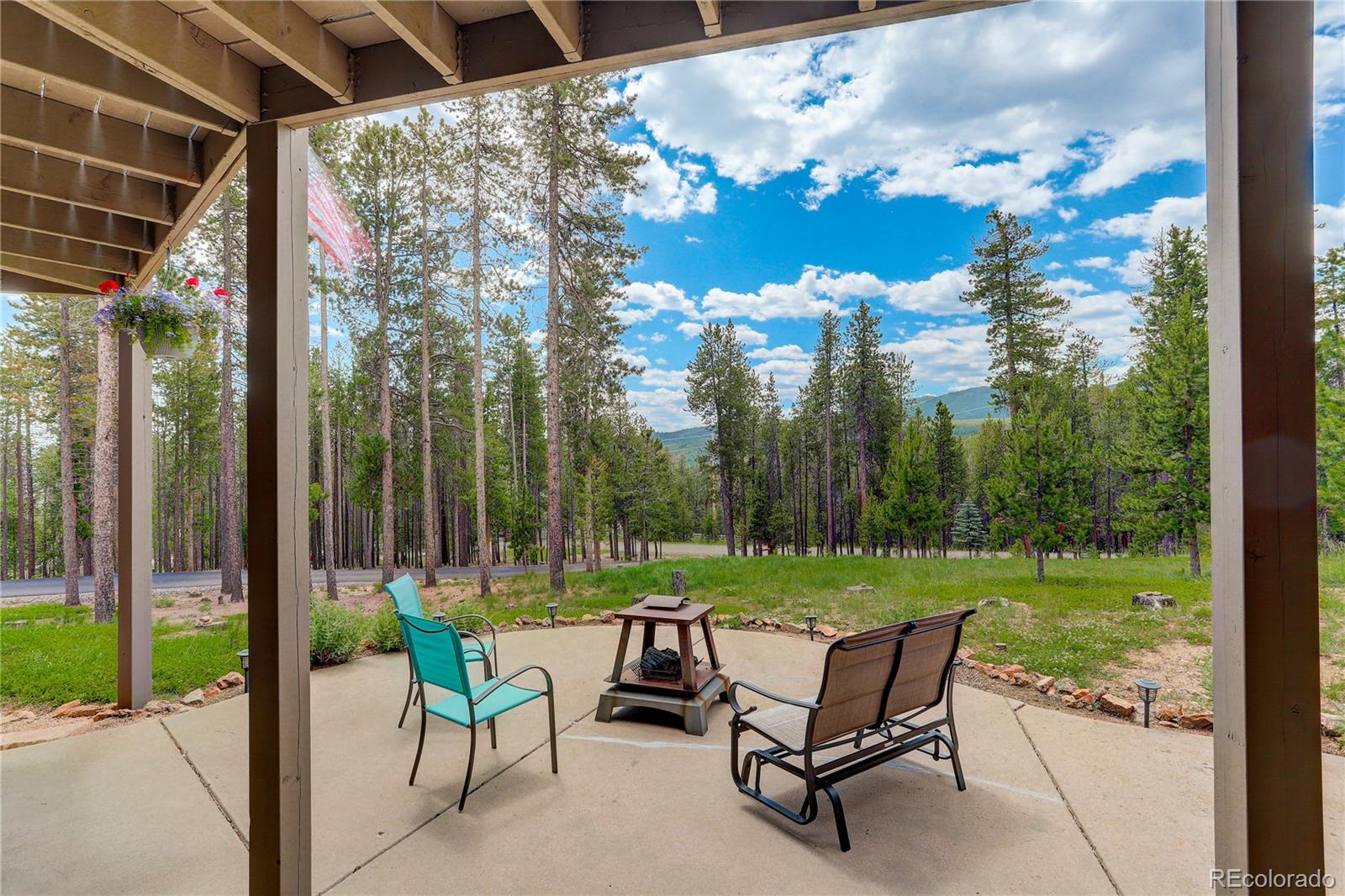 8360 South Warhawk Road Conifer, CO 80433 - Photo 30 of 40 a view of a chairs and table in patio with a small yard