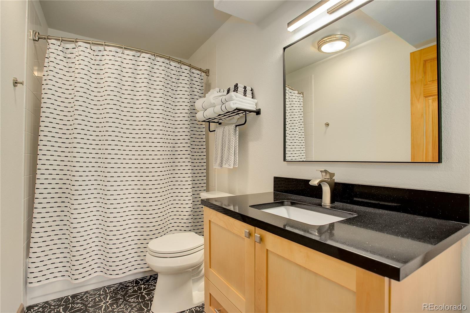 8360 South Warhawk Road Conifer, CO 80433 - Photo 33 of 40 a bathroom with a granite countertop sink toilet and mirror