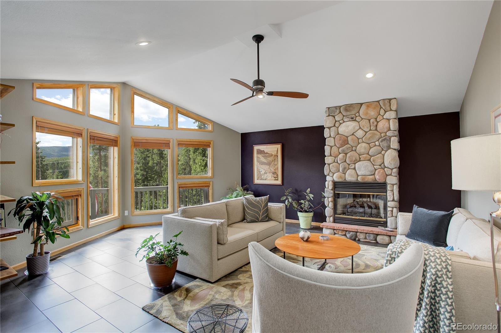 8360 South Warhawk Road Conifer, CO 80433 - Photo 8 of 40 a living room with furniture a chandelier and a potted plant