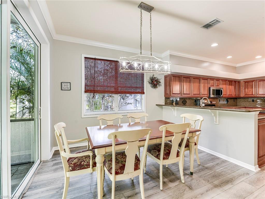 21281 Braxfield Loop Estero, FL 33928 - Photo 11 of 42 a dining room with furniture a kitchen and chandelier