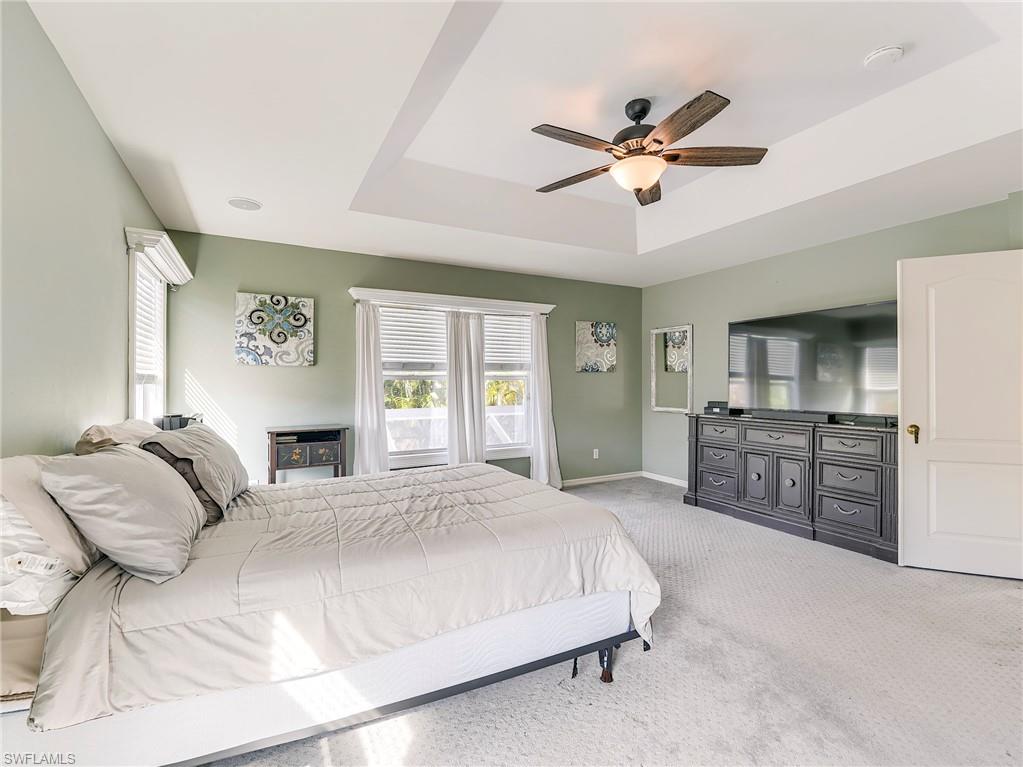21281 Braxfield Loop Estero, FL 33928 - Photo 17 of 42 a bedroom with a large bed and a ceiling fan