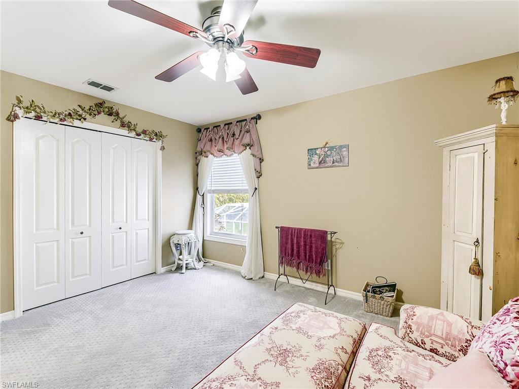 21281 Braxfield Loop Estero, FL 33928 - Photo 29 of 42 a bedroom with a bed and a chandelier