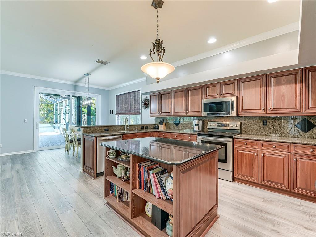 21281 Braxfield Loop Estero, FL 33928 - Photo 8 of 42 a kitchen with stainless steel appliances granite countertop a stove a sink dishwasher and a microwave oven with cabinets