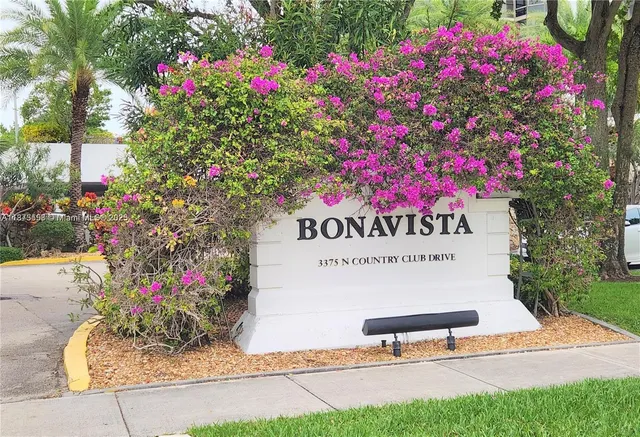 a sign that is sitting in front of flowers