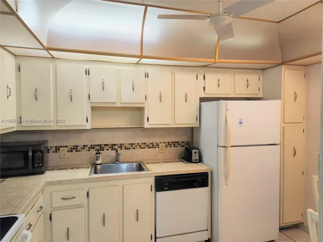 a kitchen with cabinets appliances and a counter space