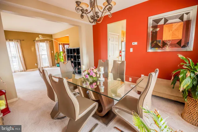a dining room with furniture a chandelier and wooden floor