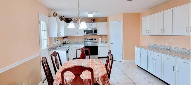 a kitchen with kitchen island granite countertop a sink a center island and stainless steel appliances