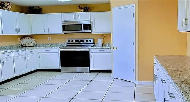 a kitchen with stainless steel appliances granite countertop a stove a sink and a microwave