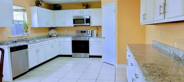 a kitchen with stainless steel appliances granite countertop a stove a sink and a refrigerator