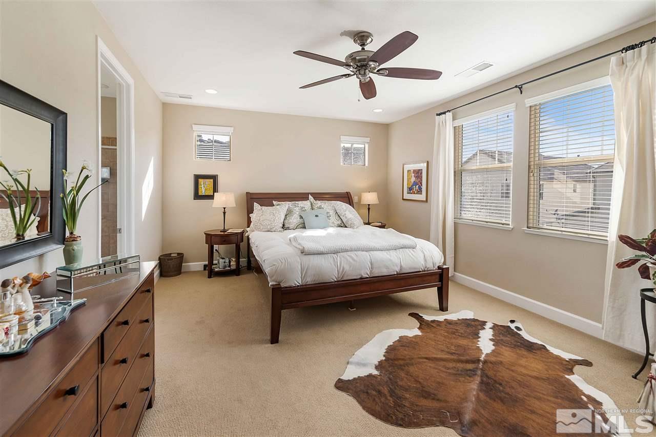 1680 Sawtooth Trail Reno, NV 89523 - Photo 15 of 24 a bedroom with a bed a couch and a large window with wooden floor