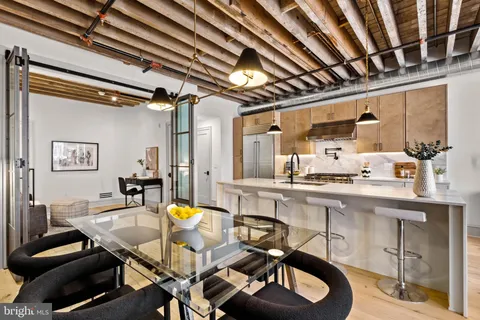 a room with stainless steel appliances kitchen island granite countertop furniture and a sink