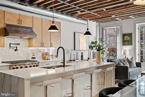 a kitchen with stainless steel appliances a sink a table and chairs
