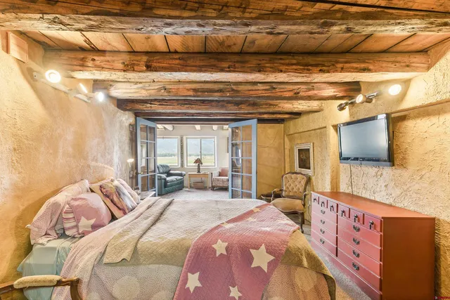 a bedroom with bed and wooden floor