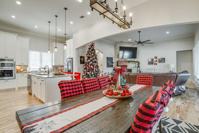 a room with lots of white furniture and kitchen view